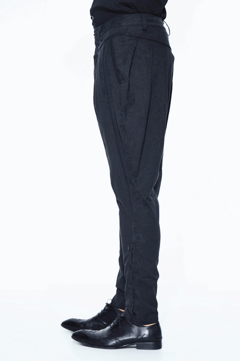 Side view of men's goth baggy black trousers with delicate pattern, styled with black dress shoes.