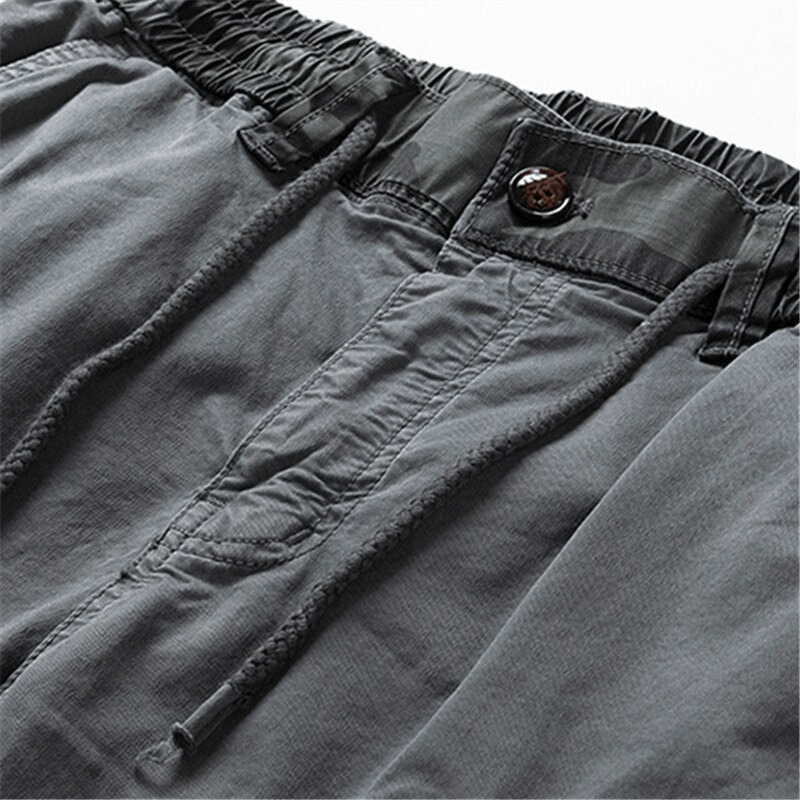 Close-up of men's joggers with elastic waist and drawstring in gray, showcasing modern style and comfort.