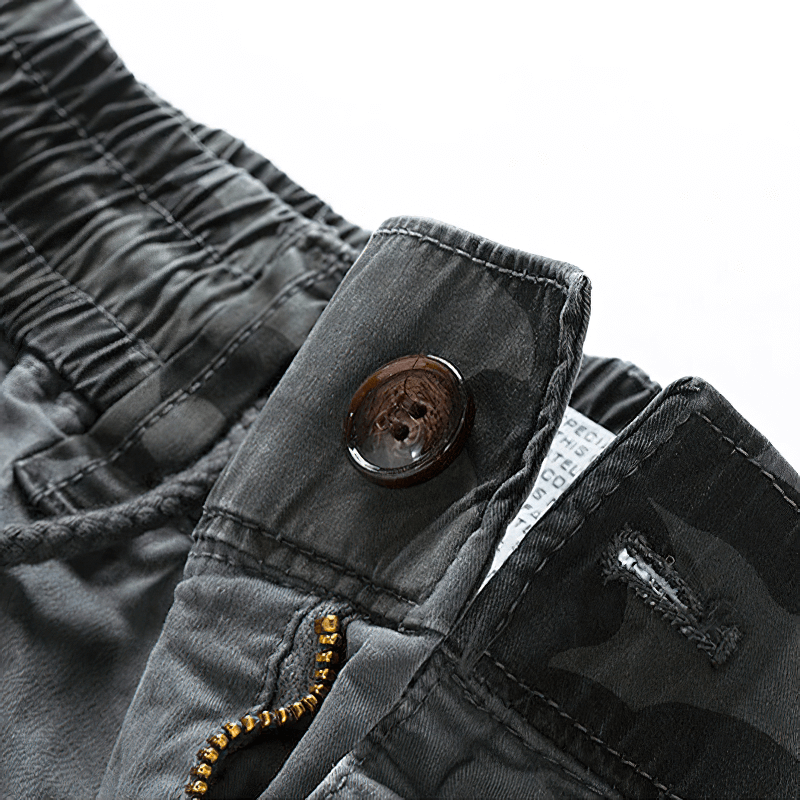 Close-up of men's joggers showcasing camouflage elements and elastic waist, perfect for streetwear style.