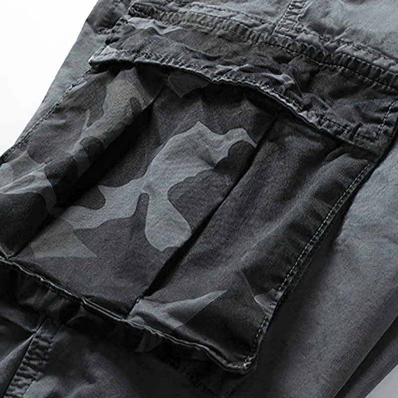 Close-up of men's joggers featuring stylish camouflage elements in gray fabric, perfect for trendy streetwear.