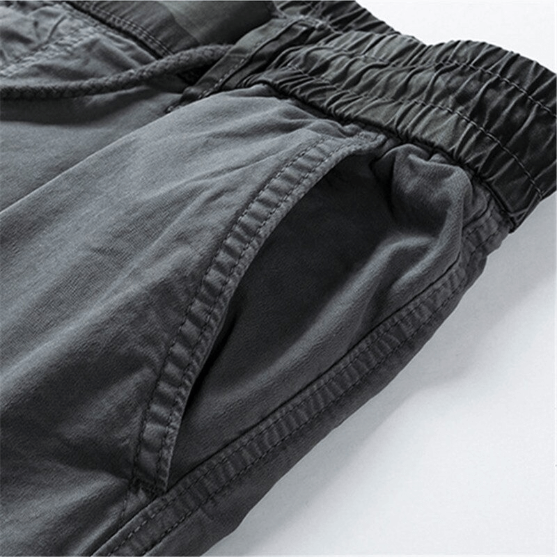 Close-up of men's joggers showcasing elastic waist and cargo pockets, perfect for casual streetwear outfits.
