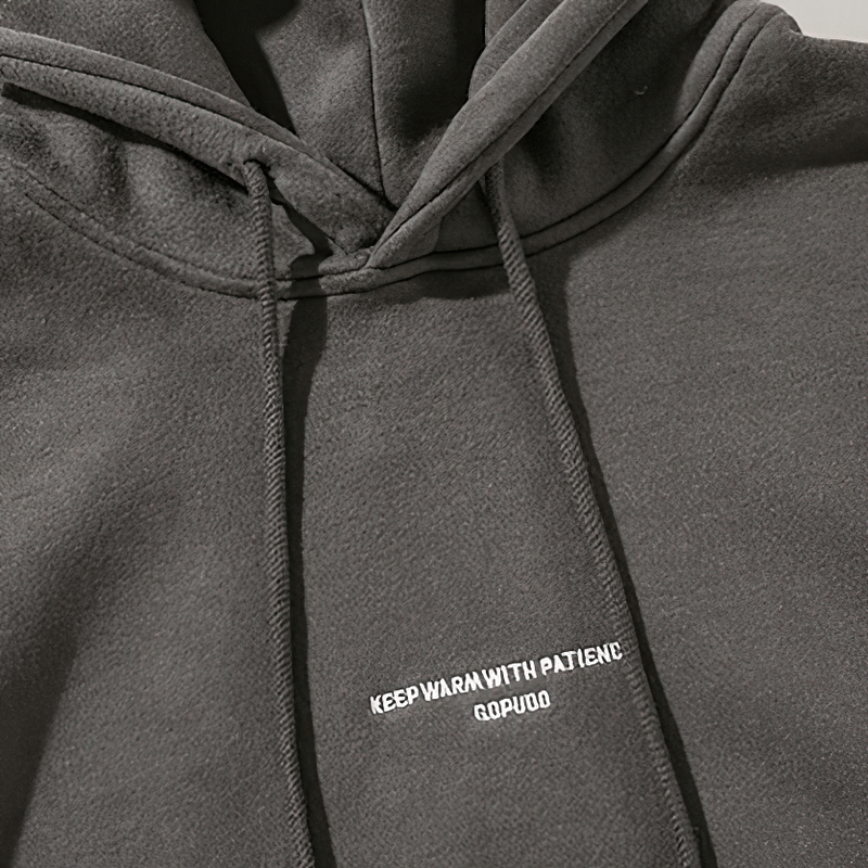 Men's dark gray fleece hoodie with drawstring, featuring the text 'Keep Warm With Patience' in white.