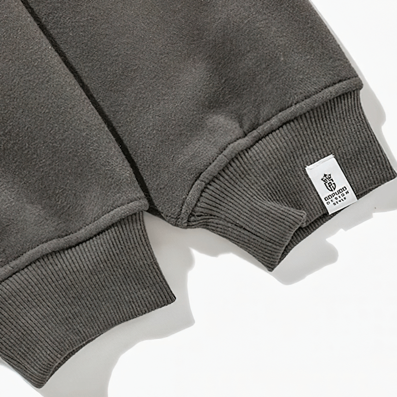 Close-up of men's fleece hoodie cuff showcasing the ribbed design and brand tag for stylish alternative fashion.