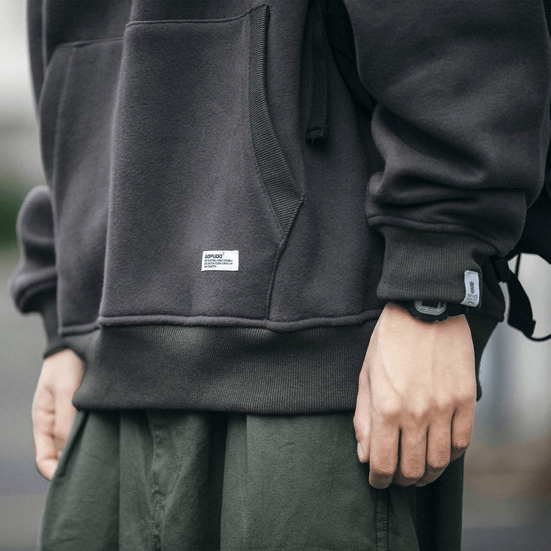 Stylish men's black fleece hoodie with drawstring, featuring a loose fit and trendy pocket design.