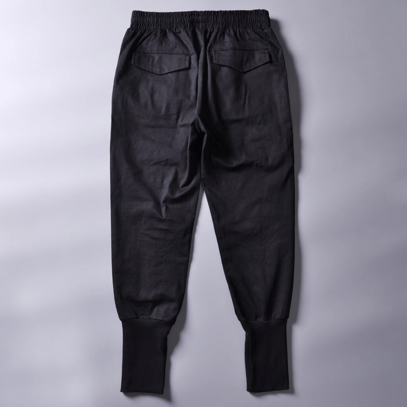 Back view of men's multi-pocket black cargo joggers, featuring an elastic waistband and stylish taper fit.