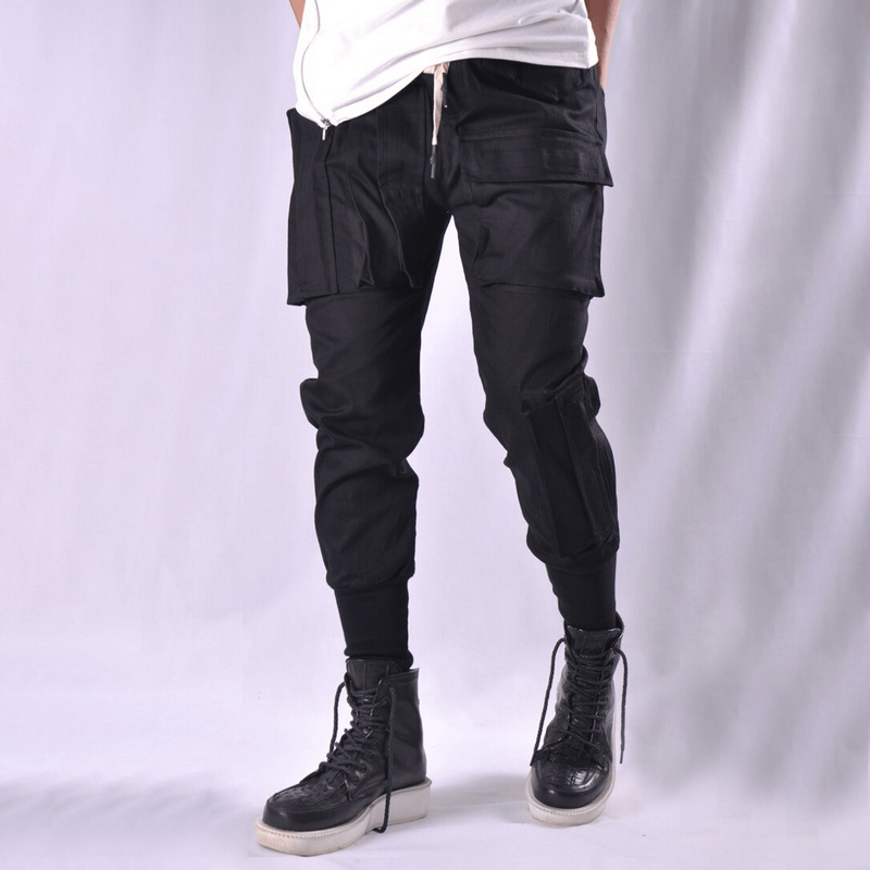 Men's multi-pocket black cargo joggers with stylish cut and trendy alternative design, paired with sleek combat boots.
