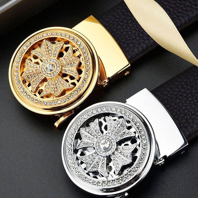 Close-up of elegant men's automatic belt buckles in gold and silver with intricate designs and sparkling rhinestones.