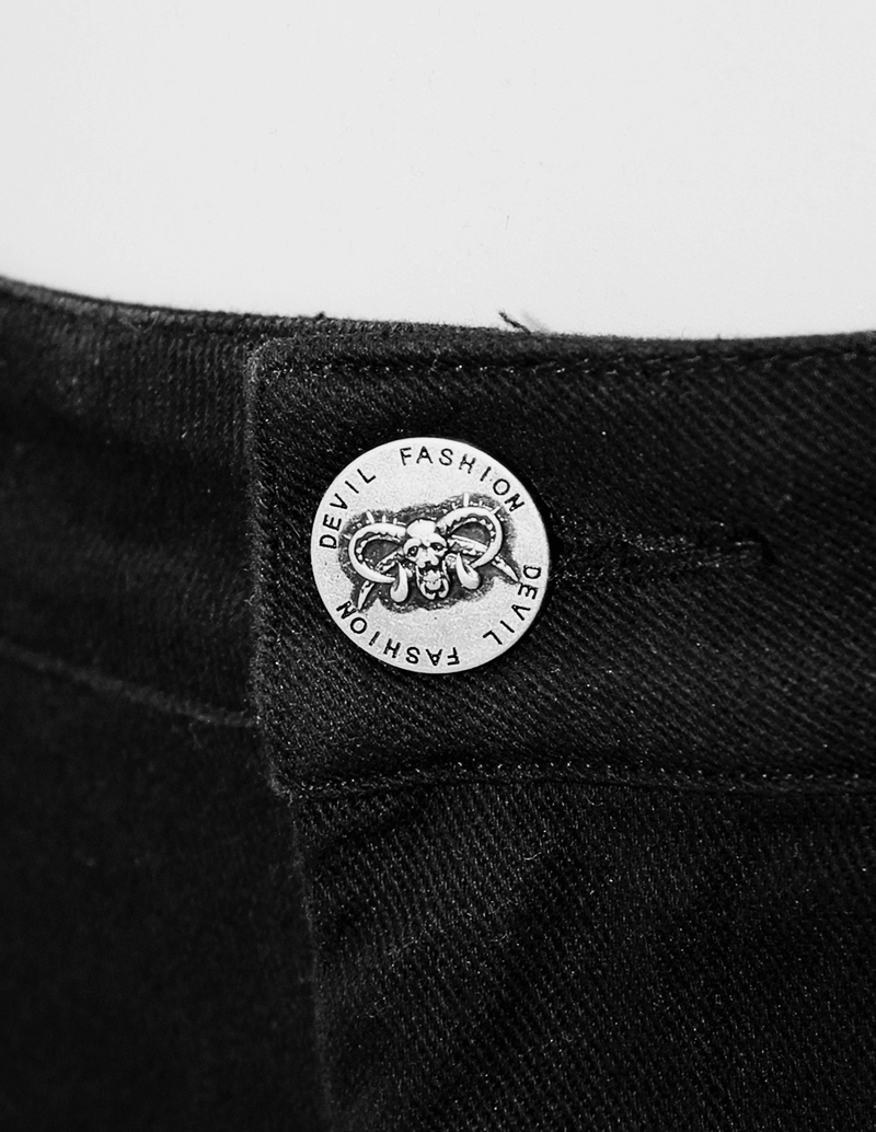 Close-up of a silver rivet with a devil emblem on stylish black punk pants, showcasing unique design and quality craftsmanship.