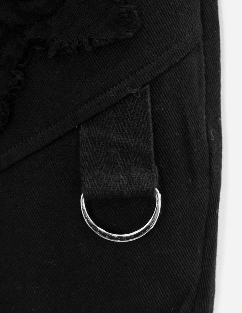 Close-up of men's black punk pants detail featuring a silver metal ring and stylish fabric accents.