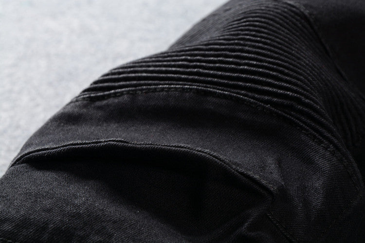 Close-up of men's black biker jeans showing unique pleated design, perfect for goth and rock styles.