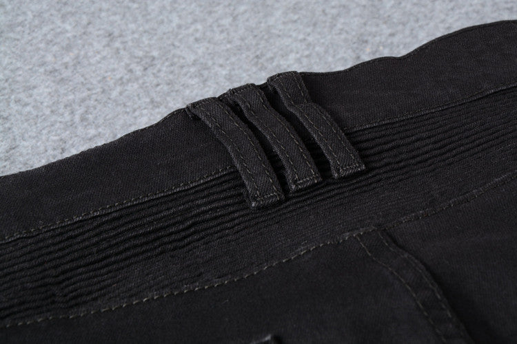 Close-up of black biker jeans waistband with pleated detail, perfect for gothic and rock style outfits.