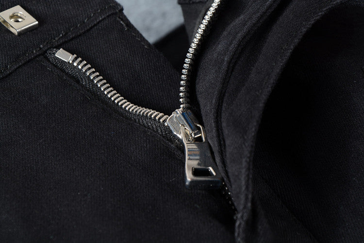 Close-up of black biker jeans zipper and pleated decor, showcasing goth and rock fashion style details.