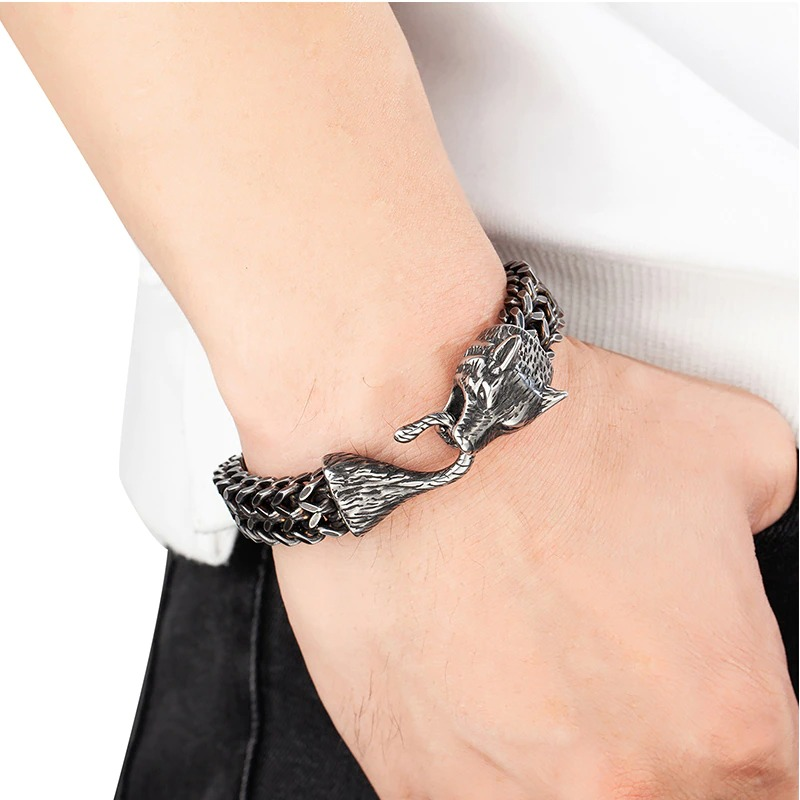 Men's vintage black wolf head bracelet in stainless steel on wrist, perfect for fashionable outfits.