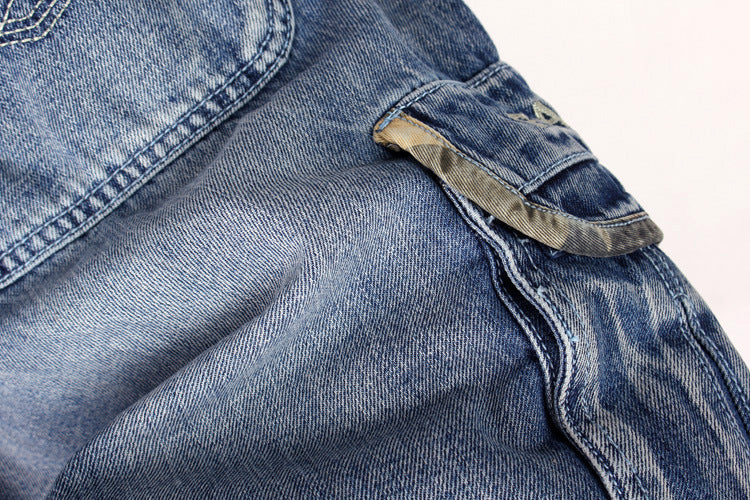 Close-up of men's blue denim cargo shorts featuring pockets and a loose fit, perfect for streetwear fashion.