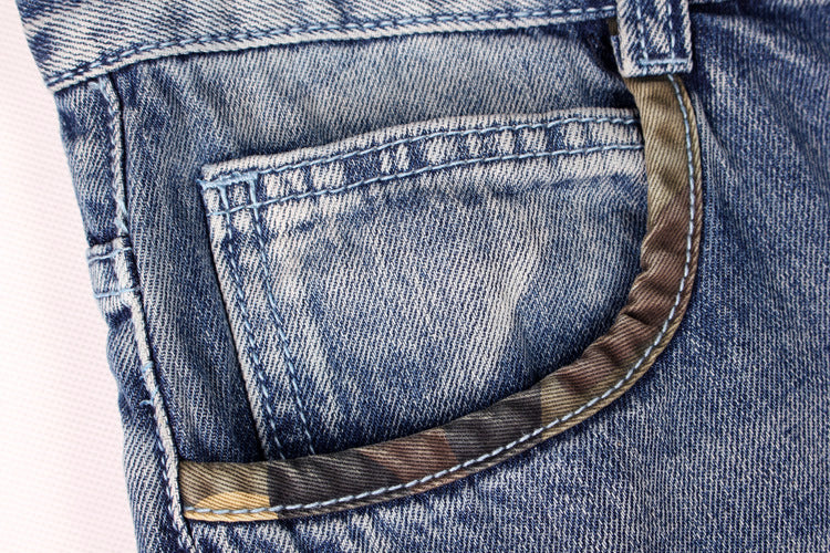 Close-up of men's denim shorts pocket featuring unique lining and durable fabric, ideal for streetwear fashion.