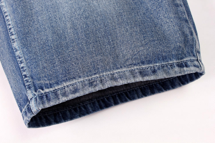 Close-up of the cuff of men's denim shorts, showcasing the soft fabric and stylish hemline.