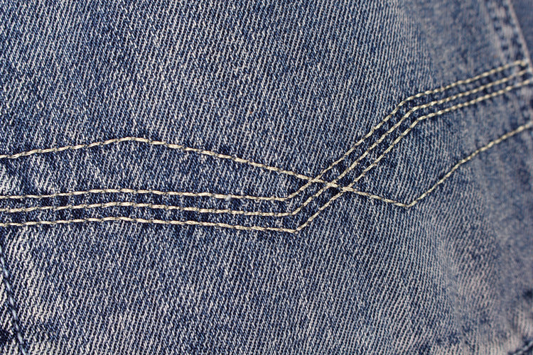 Close-up of blue denim fabric showcasing detailed stitching for men's cargo shorts.