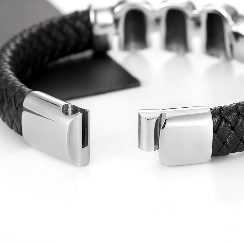 Close-up of a black braided leather bracelet with a stylish stainless steel magnetic buckle.