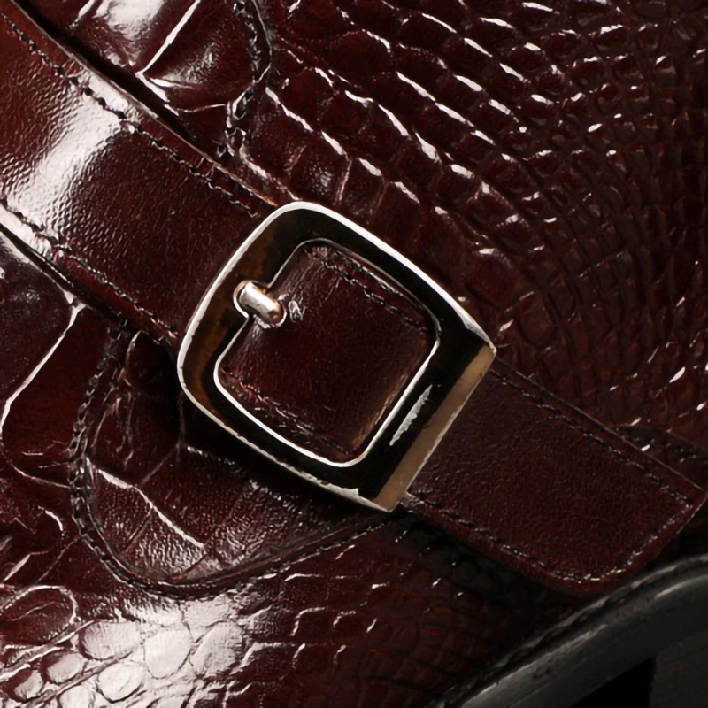 Close-up of a stylish brown leather boot buckle, showcasing its luxurious texture and elegant design.
