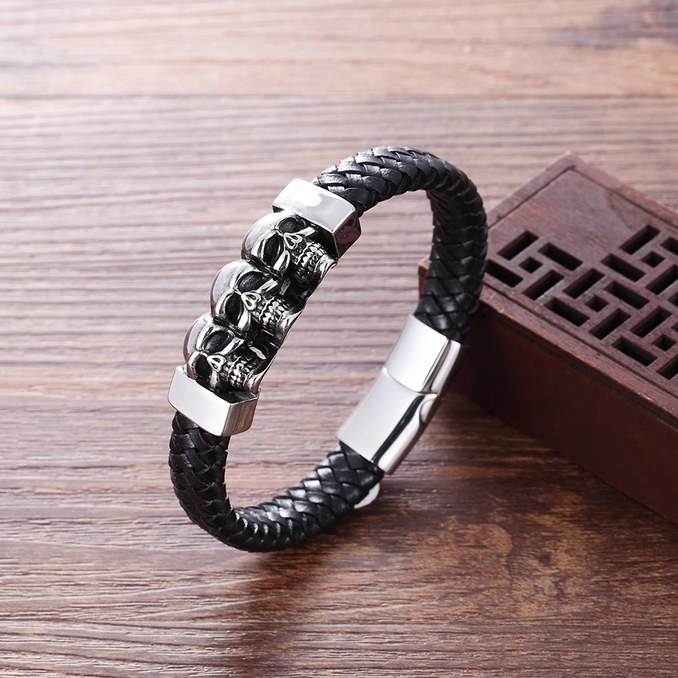 Men's genuine leather skulls bracelet with stainless steel clasp, featuring three silver skull charms in gothic style.