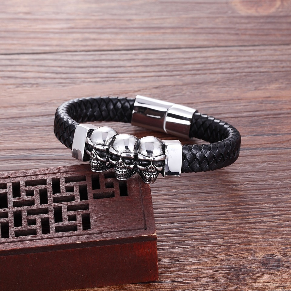 Men's gothic leather skulls bracelet with stainless steel clasp and three silver skull charms.