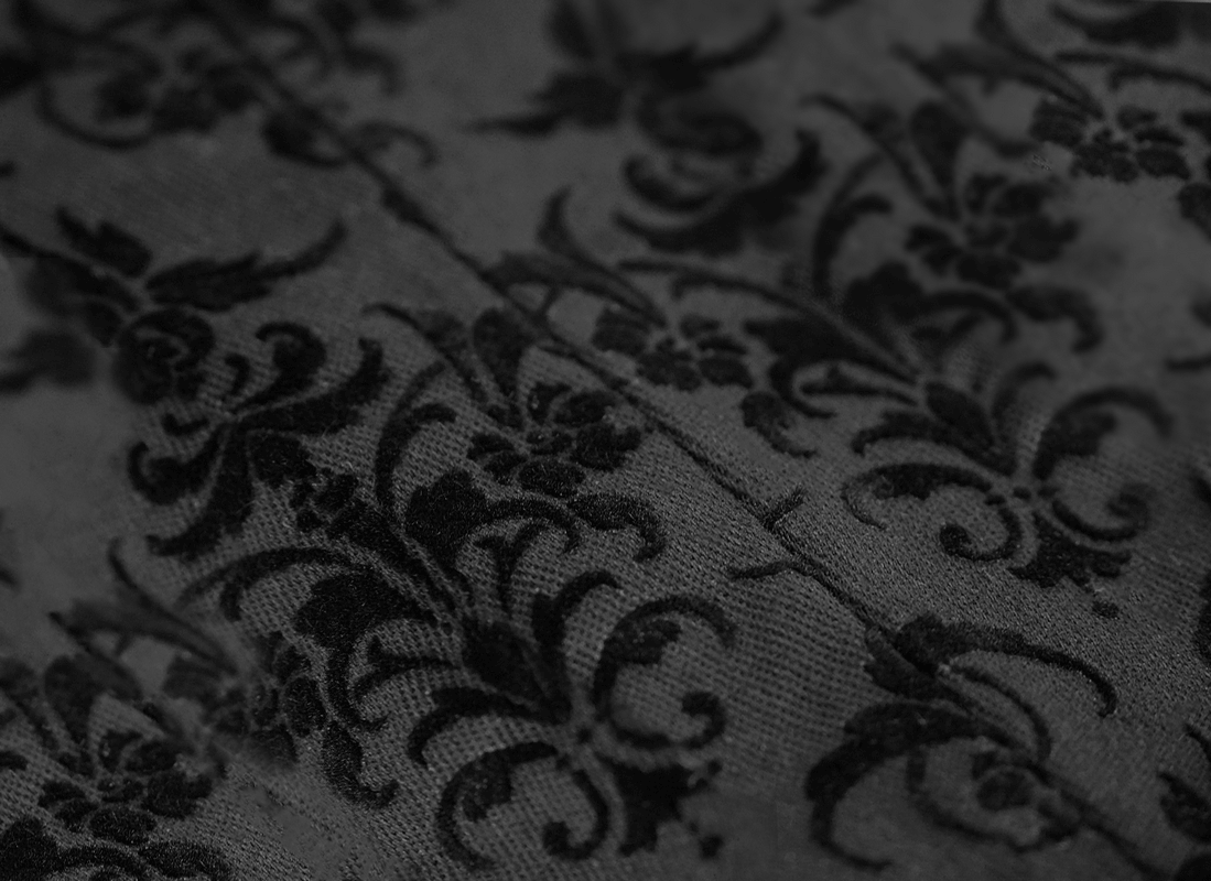 Close-up of gothic jacquard fabric with intricate black floral pattern for stylish men's pants.