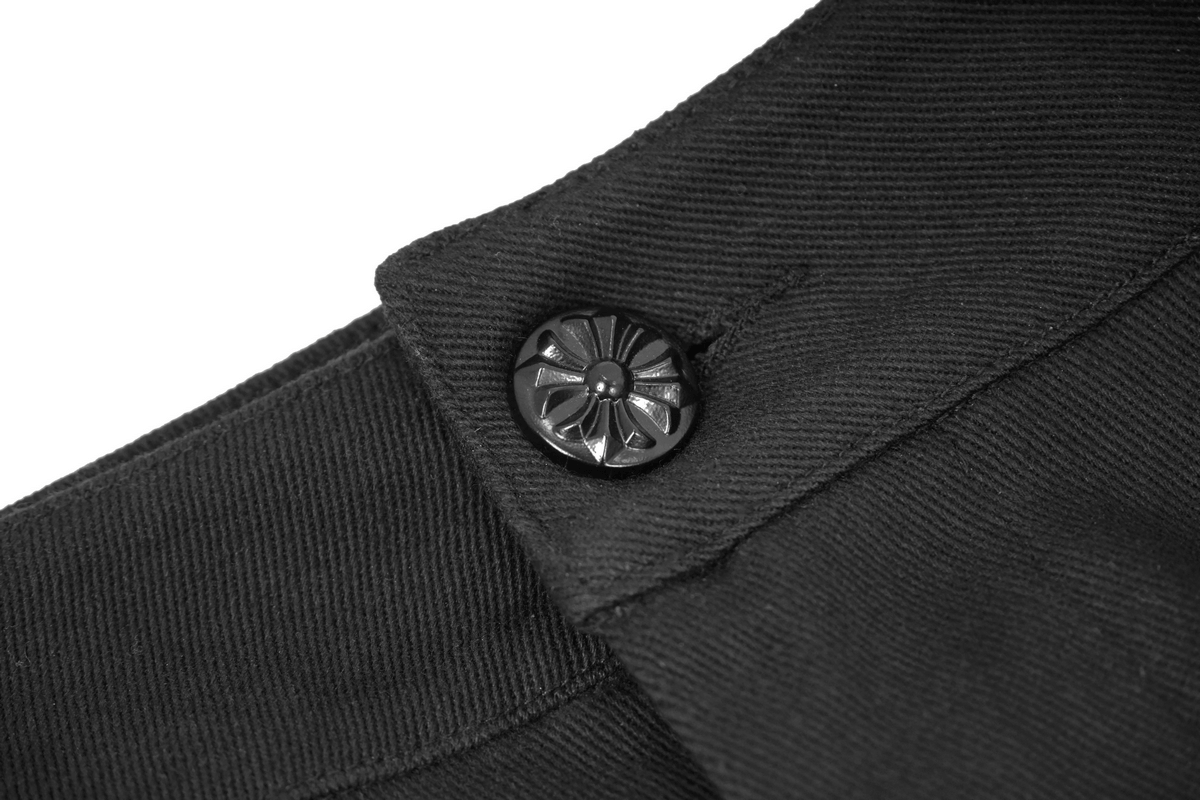 Close-up of black jacquard fabric with decorative button on men's gothic pants.