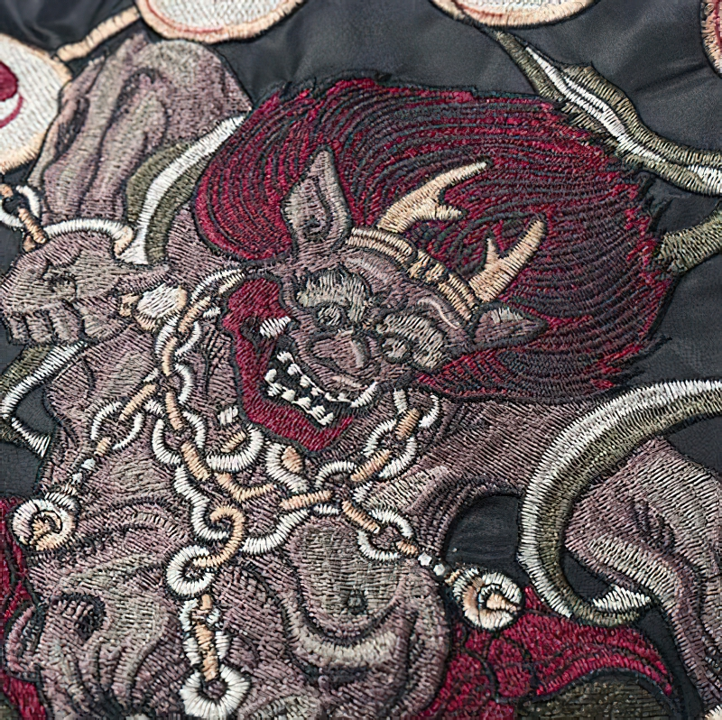 Detailed embroidered design on a men's black oversized jacket, showcasing bold streetwear graphics.