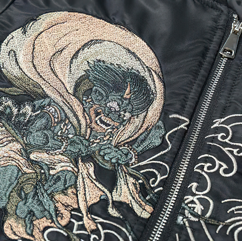 Close-up of intricate embroidery on a black oversized men's jacket, featuring a bold design and stylish pattern.