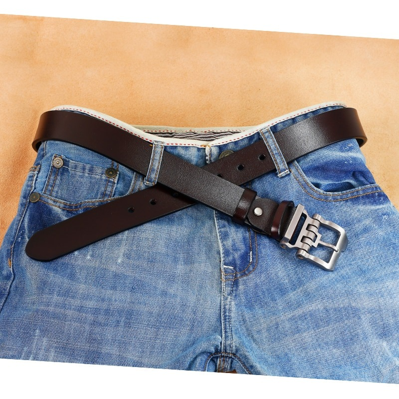 Men's leather belt crossed over blue jeans with silver alloy buckle, stylish casual accessory for any outfit.