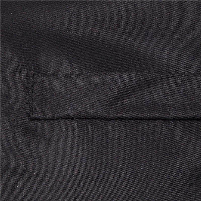 Close-up of the fabric detail of a men's long shirt in solid black, showcasing its smooth texture and quality.