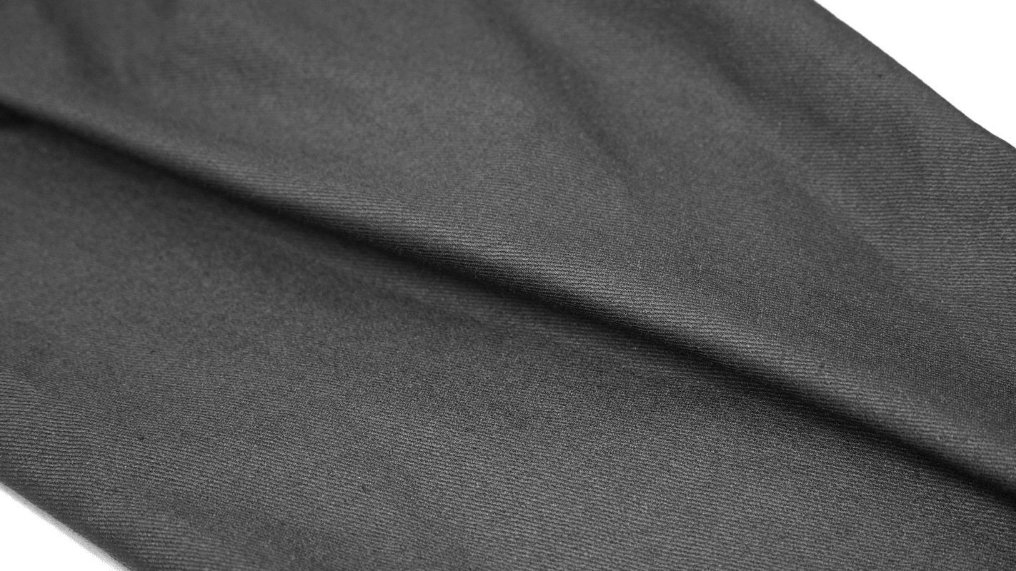 Close-up of textured black fabric showcasing the stylish material of men's skinny trousers.