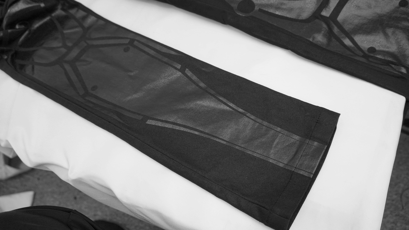 Close-up of men's black cyberpunk pants showcasing spliced stripes and sleek design on a white surface.