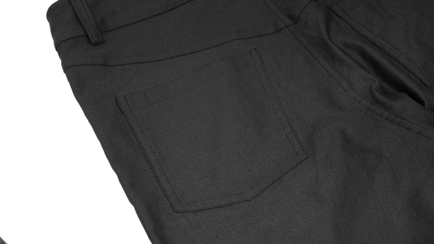 Close-up of men's cyberpunk style black trousers showcasing the back pocket detail.