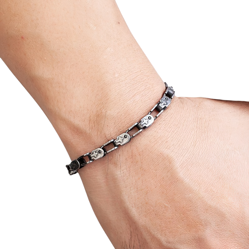 Close-up of a men's dark gray punk style stainless steel bracelet on a wrist, featuring unique cross designs.