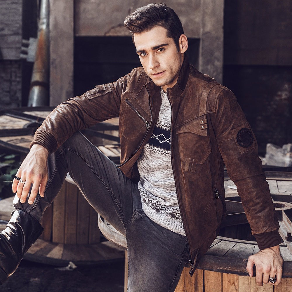 Stylish man in a vintage brown leather jacket, showcasing alternative style clothing and rugged fashion.