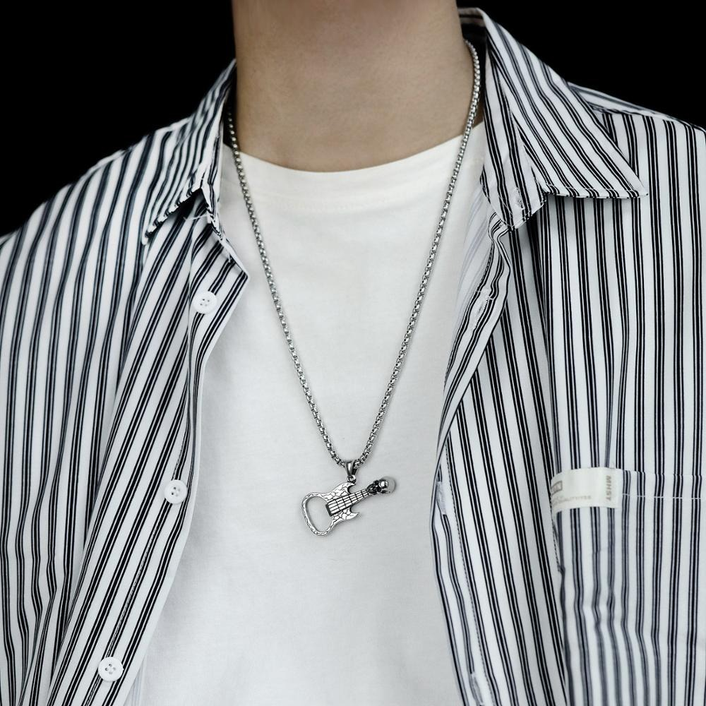 Men's guitar pendant necklace in rock style worn over a striped shirt, adding edgy flair to any outfit.