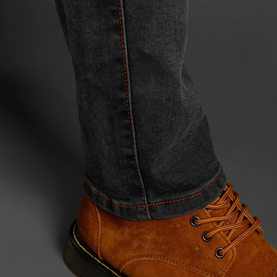 Men's slim biker jeans close-up with brown boots showcasing stylish design and fitted cut.