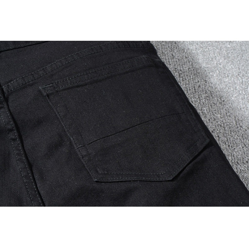 Close-up of the back pocket on men's slim ripped jeans, featuring a sleek black design, perfect for punk fashion.
