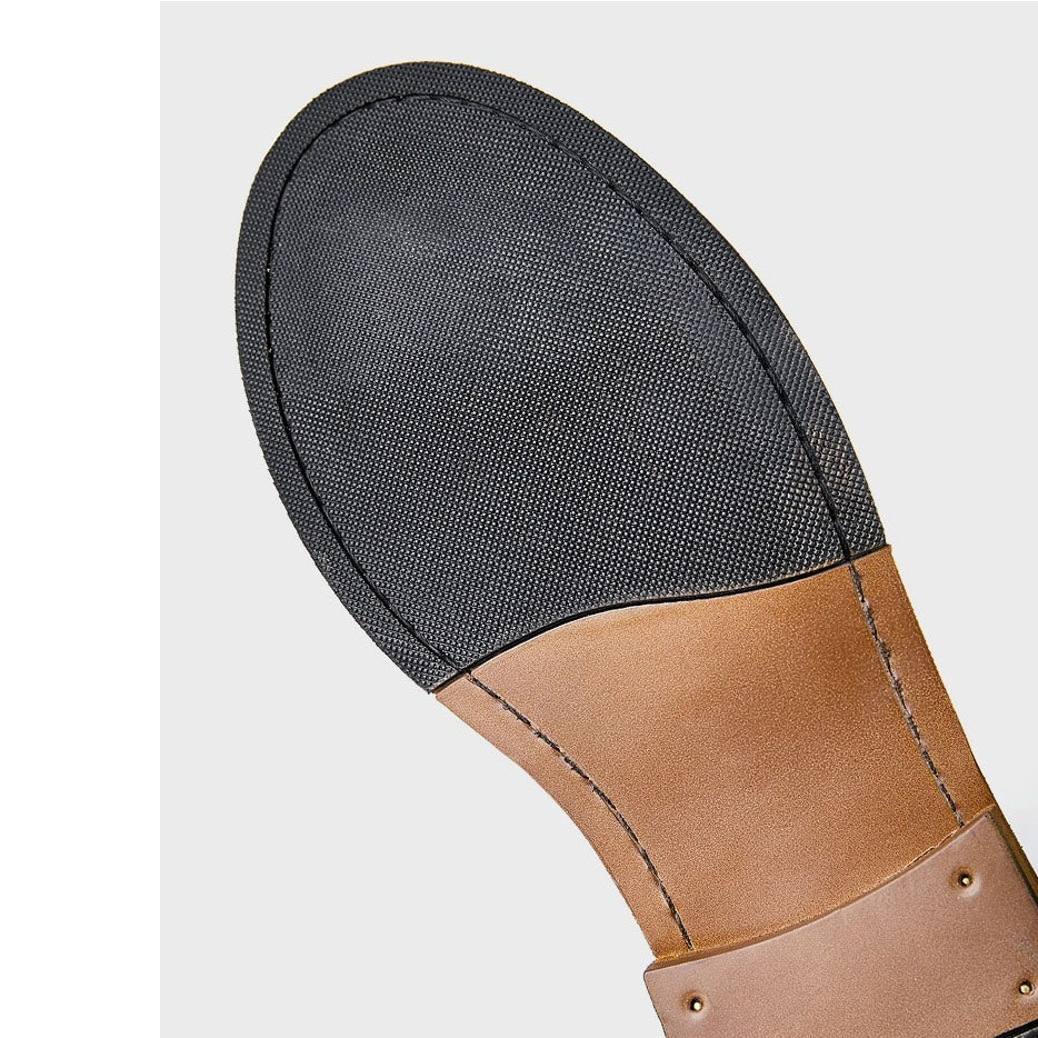 Close-up of the durable sole of men's leather ankle boot, showcasing modern design and sturdy grip.