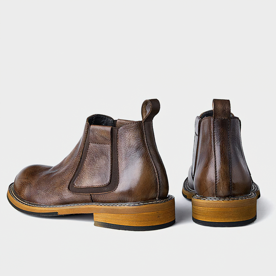Men's soft leather ankle boots in brown, showcasing a modern casual style with round toe and wooden sole.