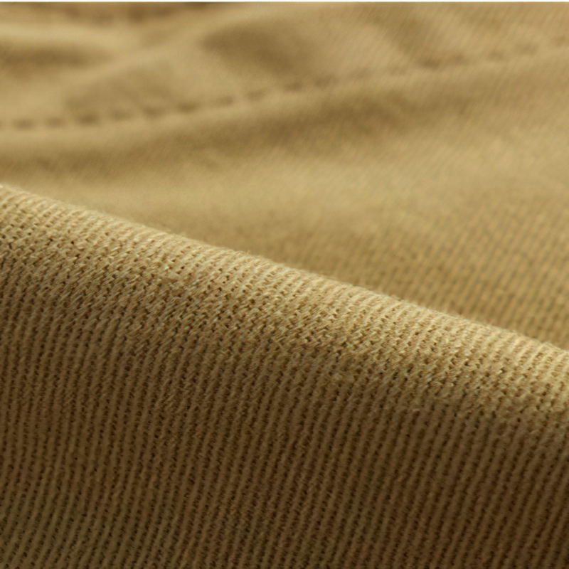 Close-up of soft, durable fabric of men's cargo shorts in a warm beige color, ideal for summer outings.