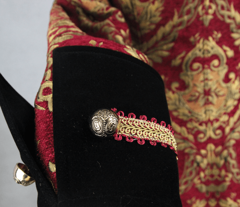 Close-up of the intricate embroidery and button detail on a Men's Steampunk Gothic Coat in red and gold.