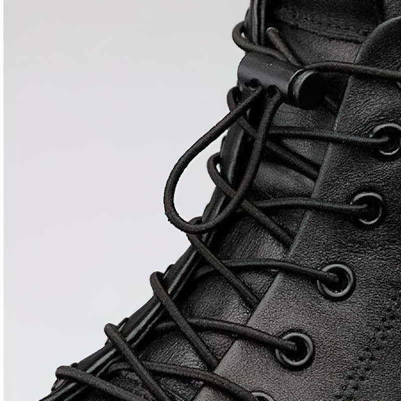 Close-up of black leather ankle boot showcasing laces and modern design for stylish casual footwear.
