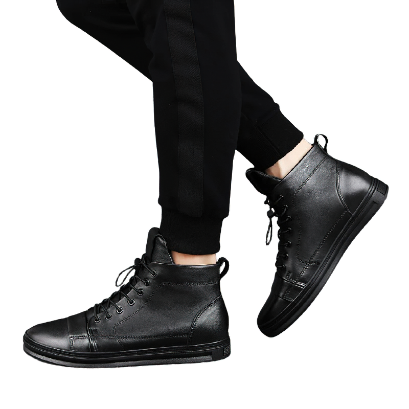 Stylish men's black leather ankle boots worn with casual pants, perfect for comfort and modern casual looks.