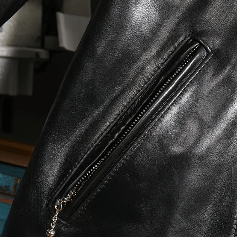 Close-up of the zippered pocket on a black waxed horsehide motorcycle jacket showcasing its sleek design.
