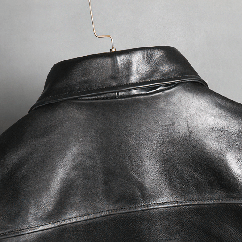 Close-up of the collar and back of a black waxed horsehide motorcycle jacket, showcasing its classic biker style.