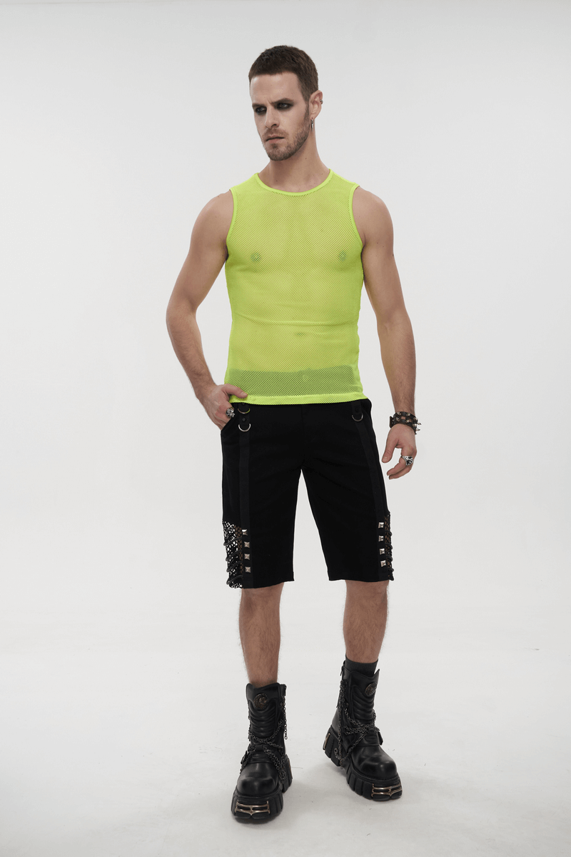 Stylish men’s sleeveless yellow mesh tank top paired with black shorts and chunky boots, showcasing alternative fashion.