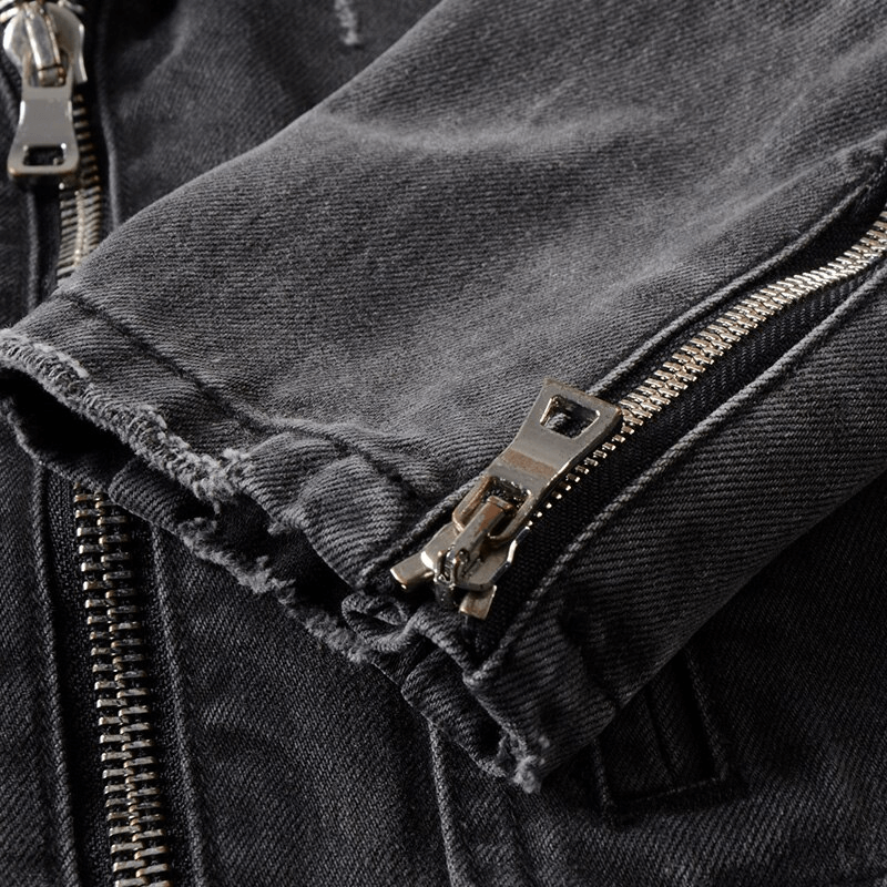 Close-up of men's black denim biker jacket with zippers and rolled cuffs for a classic rock style.