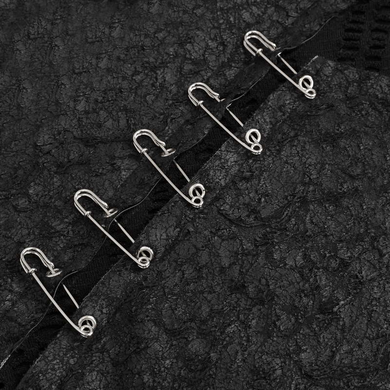 Close-up of silver safety pins on a textured black fabric, highlighting gothic fashion details.